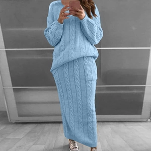 Détail du tricot torsadé bleu clair sur pull à manches longues et jupe longue assortie