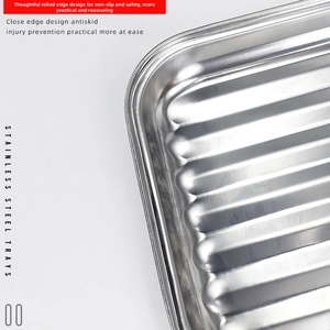 Close-up of stainless steel BBQ tray featuring rolled edges and non-slip striped bottom