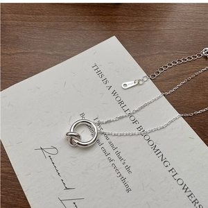 Macro shot of S925 sterling silver knot pendant necklace on minimalist gift card