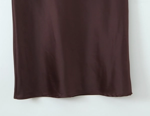 Close-up of chocolate brown satin dress hem showing smooth silk texture and fine stitching