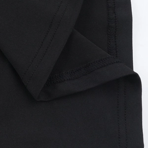 Macro detail of high-quality double-needle stitching on black knitted fabric vest
