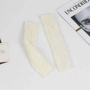 Detailed macro view of white cable knit arm warmers made of soft acrylic yarn