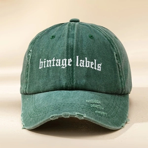 Détail d'une casquette baseball vert foncé usée avec broderie vintage labels blanche