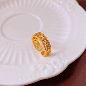 Détail d'une bague double couche plaquée or avec zircons sur une assiette blanche
