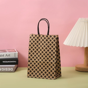 Sac cadeau en papier kraft marron à pois noirs avec poignées en corde torsadée