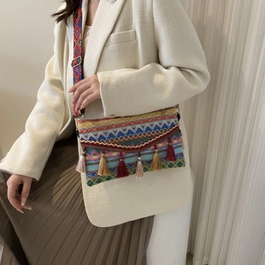 Detail of bohemian woven crossbody bag featuring colorful geometric patterns and tassels