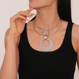 Detail van zilveren dubbellaagse metalen choker met een grote ronde getextureerde hanger