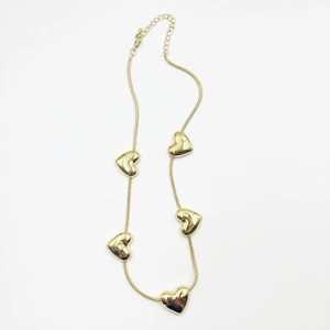 Detail of gold snake chain necklace featuring five 3D heart pendants and lobster clasp