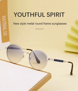 Fashionable silver round frame sunglasses with gradient lenses on a warm background