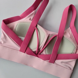 Detail of pink yoga bra featuring criss-cross back straps and breathable green padding