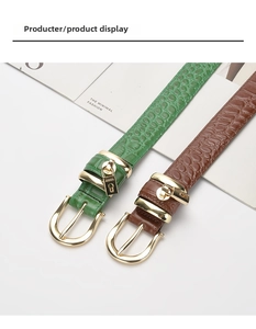 Detail of crocodile embossed leather belts in green and brown with gold buckles