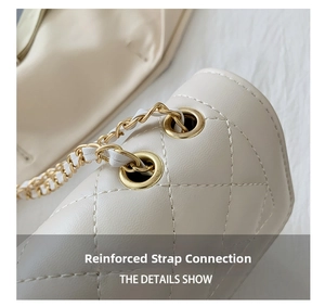 Detail of metal grommets and quilted stitching on beige chain crossbody bag strap