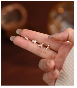 Detailed close-up of four geometric S925 silver gold-plated stud earrings with zircon stones