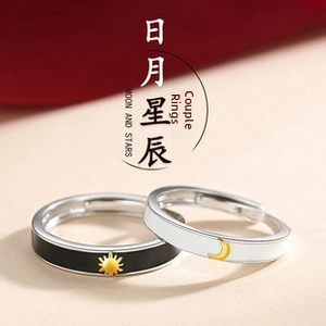 Close-up of adjustable sun and moon rings with black and white enamel finishes