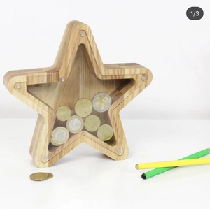 Star-shaped wooden money box with transparent panel and coins on white background