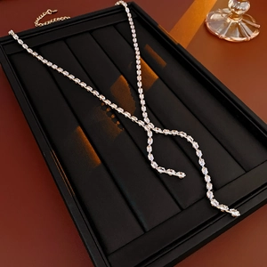 Detailed view of silver zircon water drop tassel necklace on black display tray