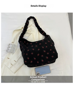 Detail of corduroy shoulder bag with strawberry print and smartphone for size reference