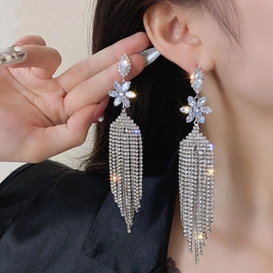 Elegant silver flower tassel earrings with zircons shown on a model side profile