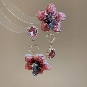 Dettagli degli orecchini a fiore ricamati con cristalli ed elementi metallici a cuore