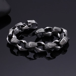 Macro di un bracciale in acciaio inossidabile grigio scuro con maglie ruvide e riflessi