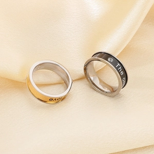 Detailed view of couple rings with 'love' engraving and zircon inlay on champagne silk