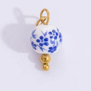 Detailed view of blue and white floral ceramic bead pendant with gold accents