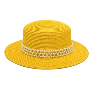 Detailed texture of yellow straw boater hat with elegant white pearl mesh decoration