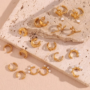 Détail de manchettes d'oreilles dorées avec motifs serpent, perles et zircons