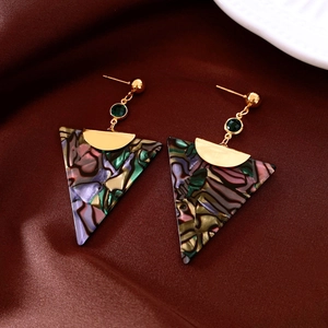 Detail of triangle acetate drop earrings with vintage colorful texture on red satin
