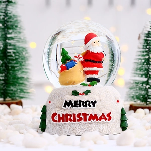 Vue détaillée d'une boule à neige de Noël lumineuse avec Père Noël et socle décoré