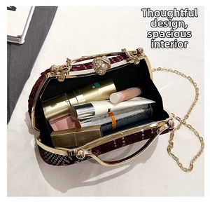 Detailed view of burgundy sequin clutch interior with chain strap and pearl clasp