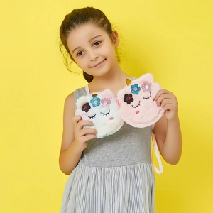Close-up of cute plush unicorn shoulder bags with colorful sequins and soft faux fur material