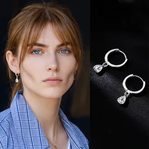 Detail of silver drop earrings with pear-shaped clear pendants and crystal zircon accents