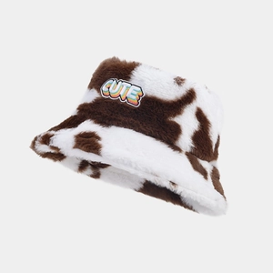 Détail du bob en peluche à motif vache avec écusson brodé CUTE multicolore