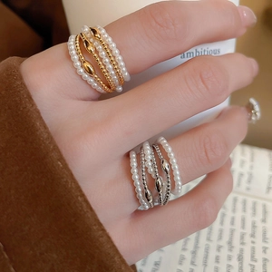 Macro detail of multilayer pearl rings with gold and silver beaded accent layers