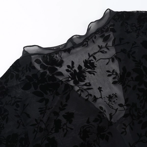 Close-up of black sheer chiffon fabric with elegant flocked floral texture and neckline detail