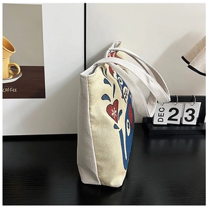 Detail view of ethnic canvas tote bag showing side embroidery and thick fabric texture