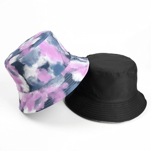 Detail of reversible tie-dye and solid black sun bucket hats with stitched brim texture