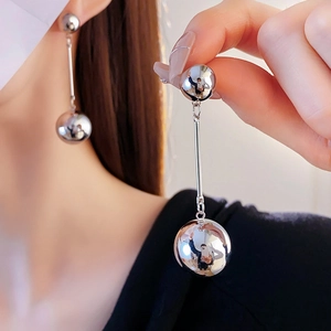 Detailed close-up of silver long ball tassel earrings showing metallic texture and drop