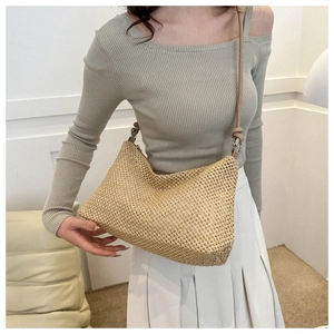 Straw woven tote bag shown on a model in a cozy interior setting for casual style