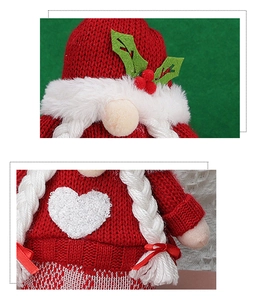 Detail of red and white knitted Christmas gnome with heart pattern and long braids