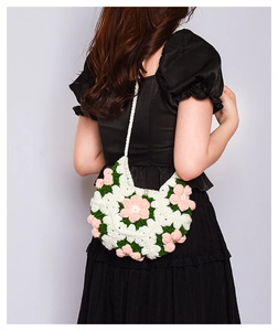 Detail of handmade 3D puff flower crochet crossbody bag with pearl button and strap