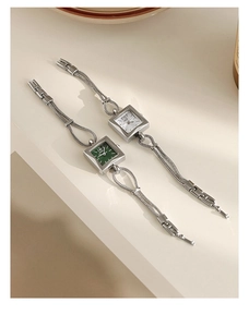 Detail view of square dial ladies' watches with elegant metal chain bracelets in green and white