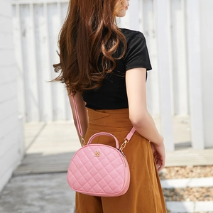 Pink quilted half-moon crossbody bag with floral gold clasp and adjustable strap