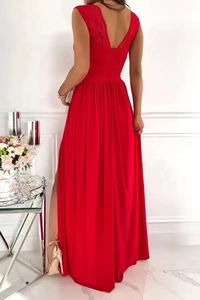 Détail de la robe en dentelle rouge montrant le dos nu et l'ourlet fendu sur un mannequin