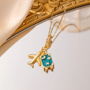 Elegant gold airplane and blue enamel suitcase pendant necklace for travel lovers