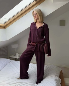 Close-up of dark purple pleated knit lounge set with polo collar and matching bag