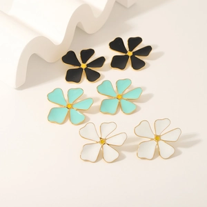 Three pairs of colorful flower stud earrings in black, cyan, and white with gold borders