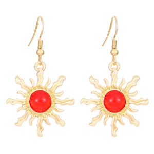 Detail of vintage sunburst earrings with gold metal rays and a red center bead