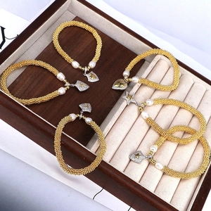 Nahaufnahme von Perlenarmbändern mit Zirkonia-Anhängern auf einem Samt-Schmuckdisplay